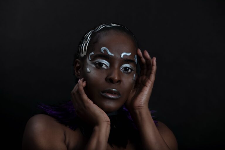 Portrait of Cyon Flex with silver makeup, hands framing her face